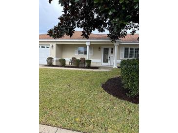 House exterior showcasing a front porch, and a neatly manicured lawn at 13981 Se 86Th Cir, Summerfield, FL 34491