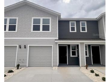 Charming townhouse featuring a blend of gray siding, attached garages, and neatly manicured landscaping at 6594 Sw 81St Loop, Ocala, FL 34476