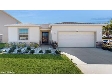 Single-story house with a two-car garage and landscaped lawn at 4388 Sw 56Th Pl, Ocala, FL 34474