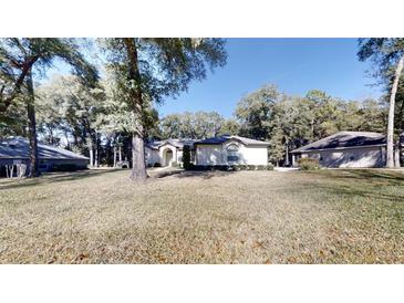 Single-story house with a large front yard and mature trees at 4475 Se 48Th Place Rd, Ocala, FL 34480