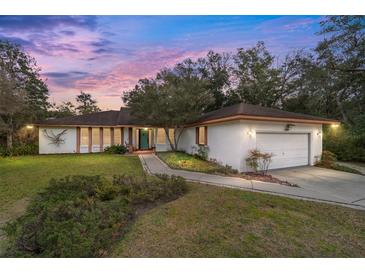 Single-story house with a two-car garage and a landscaped lawn at 9185 Sw 197Th Cir, Dunnellon, FL 34432