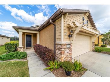 Tan house with a brown door and attached garage at 9661 Sw 63Rd Loop, Ocala, FL 34481