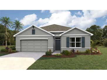 Single-story home with gray siding, two-car garage, and landscaping at 348 Hickory Course Trl, Ocala, FL 34472