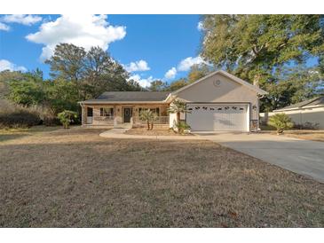 Charming home featuring a two-car garage, front porch, and well-manicured lawn at 6009 Sw 107Th St, Ocala, FL 34476
