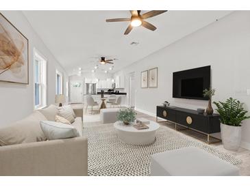 Open concept living area with modern furnishings, a neutral color palette, and hardwood flooring at 11759 Bostick St, Dunnellon, FL 34432