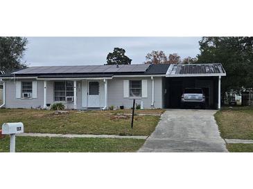 Gray house with solar panels, carport, and driveway at 137 Marion Oaks Ln, Ocala, FL 34473