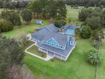 Aerial view of a two-story home, pool, and expansive acreage at 20921 Sw 36Th St, Dunnellon, FL 34431