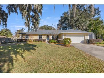 Single-story house with attached garage, lush lawn, and mature trees at 2575 Se 34Th St, Ocala, FL 34471