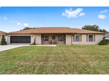 Tan house with brown roof, screened porch, and large yard at 4535 Nw 34Th Pl, Ocala, FL 34482