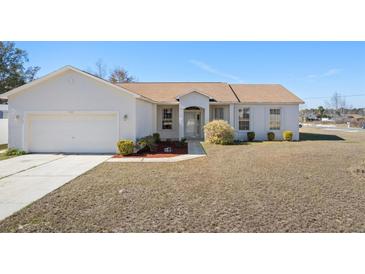 Single-story house with attached garage and landscaped lawn at 7000 Sw 129Th Pl, Ocala, FL 34473