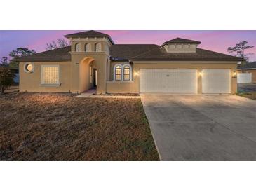 Two-story house with three car garage, neutral color exterior, and landscaping at 10384 Sw 41St Ave, Ocala, FL 34476