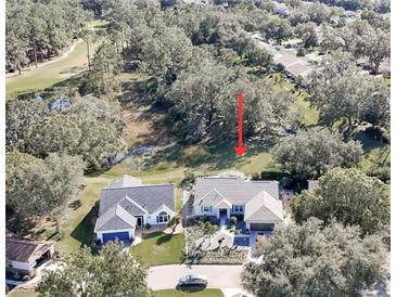 Aerial view of a house with a landscaped yard and golf course nearby at 3923 Manor Oaks Ct, Leesburg, FL 34748