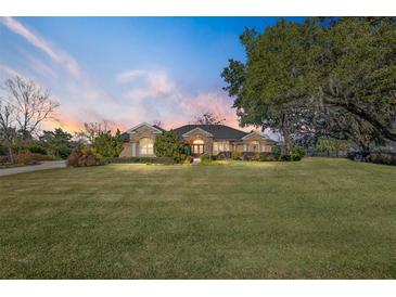 One-story home with stone accents, lush landscaping, and a large yard at 4048 Se 38Th Loop, Ocala, FL 34480