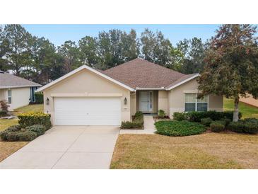 Single-story home with attached garage, landscaping, and a paved driveway at 5409 Sw 42Nd Pl, Ocala, FL 34474