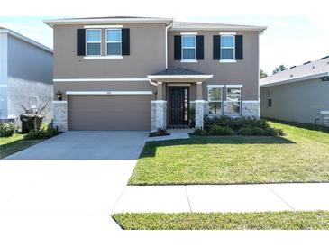 Charming two-story home with a well-manicured lawn, stone accents and a two car garage at 5429 Sw 44Th Court Rd, Ocala, FL 34474