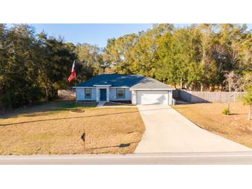 Newly constructed home with a paved driveway and American flag at 7958 Juniper Rd, Ocala, FL 34480