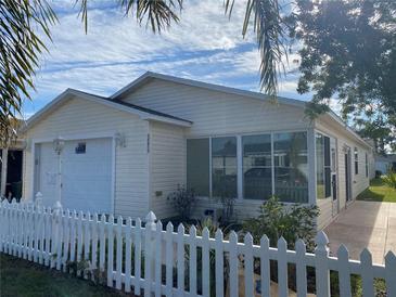 Charming single-story home featuring a white picket fence, attached garage, and inviting front porch at 1576 Bottlebrush St, The Villages, FL 32162