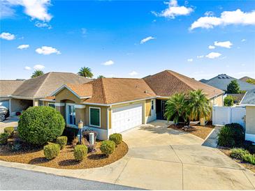 Single-story home with a two-car garage and landscaped front yard at 2997 Teasdale Ter, The Villages, FL 32163