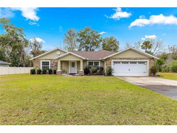 One-story house with stone accents, a two-car garage, and a spacious lawn at 3707 Se 24Th St, Ocala, FL 34471