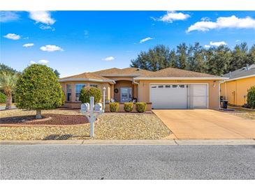 Single-story home with a two-car garage and landscaped front yard at 8125 Sw 81St Loop, Ocala, FL 34476