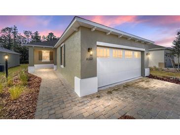 Charming home featuring a well-lit exterior, a spacious driveway, and a welcoming walkway at 10322 Sw 99Th Ln, Ocala, FL 34481