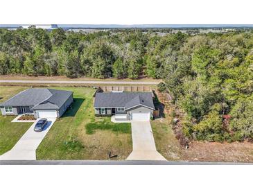 Charming single-story home boasts a well-manicured lawn, long driveway and an attached garage at 13787 Sw 43Rd Cir, Ocala, FL 34473