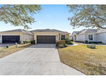 Front view of a single-story house with a two-car garage and well-manicured lawn at 6716 Sw 91St Cir, Ocala, FL 34481