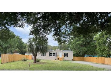 Charming home featuring a front yard, a wooden fence, and a well-maintained lawn at 9160 Sw 31St Avenue Rd, Ocala, FL 34476