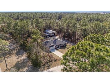 Aerial view of a house and large workshop on a wooded lot at 13700 Sw 71St Ln, Ocala, FL 34481