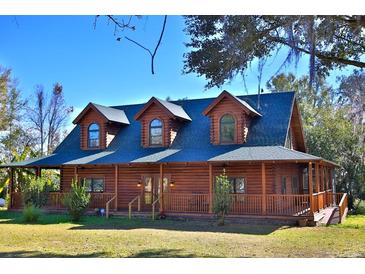 Beautiful log home with wrap-around porch and large yard at 1838 Sw 97Th Pl, Ocala, FL 34476