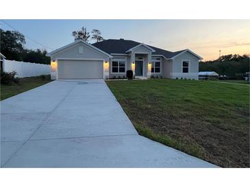 Charming single-story home featuring a well-manicured lawn and attached two-car garage at 77 Olive Dr, Ocala, FL 34472