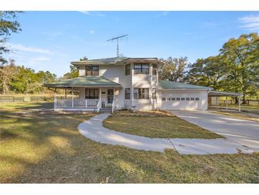 Two-story house with a green roof, white siding, and a porch at 10245 Sw 105Th St, Ocala, FL 34481