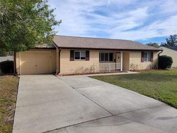 House with attached garage and a long driveway at 10973 Sw 86Th Ct, Ocala, FL 34481