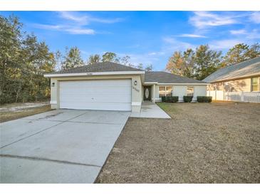 One-story house with attached garage and a well-maintained lawn at 16360 Se 88Th Ct, Summerfield, FL 34491