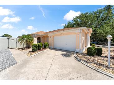 Exterior view of a single-story house with a driveway, lamp post, and landscaped yard at 1801 Marquez Loop, Lady Lake, FL 32159