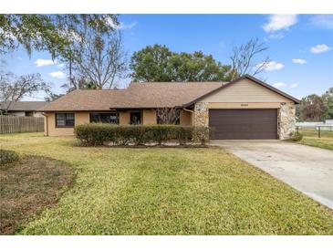 House exterior featuring a brown roof, stone accents, and a two-car garage at 2540 Se 35Th St, Ocala, FL 34471