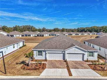 Two-car garage home with landscaped front yard and brick driveway at 5365 Nw 46Th Lane Rd, Ocala, FL 34482