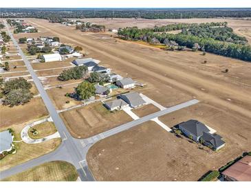 Aerial view of a home on an airfield, with surrounding properties and landscape at 7225 Se 92Nd St, Ocala, FL 34472