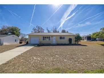 Cute yellow house with a spacious yard and a single car garage at 8274 Sw 106Th Pl, Ocala, FL 34481