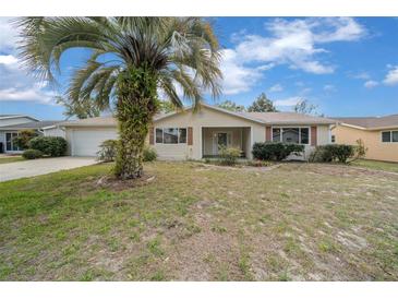 Charming single-story home featuring an attached garage and a welcoming front porch at 8450 Sw 115Th Street Rd, Ocala, FL 34481