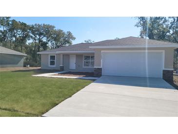 Charming single-story home featuring a two-car garage and well-manicured lawn at 17682 Sw 113Th Pl, Dunnellon, FL 34432