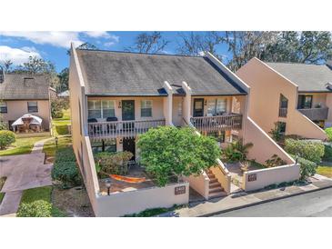 Front view of two-story condo with private patio and lush landscaping at 2418 Ne 7Th St # 10, Ocala, FL 34470