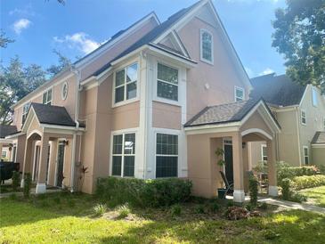 Two-story tan house with a covered porch and landscaping at 3396 Parkchester Square Blvd # 103, Orlando, FL 32835