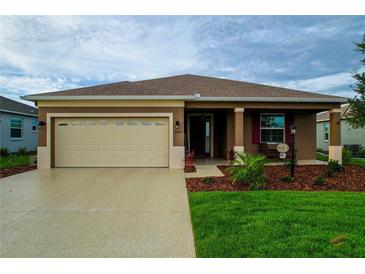 Charming single-story home featuring a two-car garage, well-maintained lawn, and inviting front porch at 8902 Sw 75Th Loop, Ocala, FL 34481