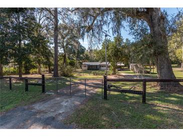 Gated property with a long driveway, lush trees and foliage provides privacy at 9352 Ne 27Th Ter, Anthony, FL 32617