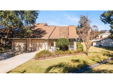 Tan and brick exterior of a condo with a two-car garage and manicured landscaping at 2321 Se 19Th Cir, Ocala, FL 34471