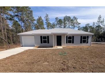 Newly constructed single-story home with a landscaped yard at 67 Nw Sparrow Rd, Dunnellon, FL 34431