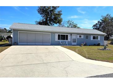 Ranch-style home with carport, screened patio, and well-manicured lawn at 11123 Sw 76Th Ter, Ocala, FL 34476