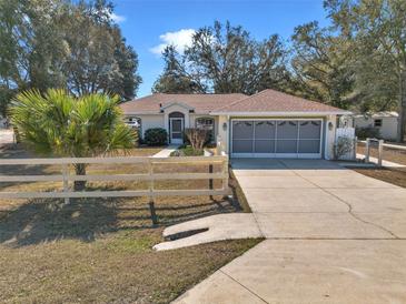 Charming single-story home with well-manicured lawn, mature trees, and a two-car garage at 13370 Sw 112Th Pl, Dunnellon, FL 34432