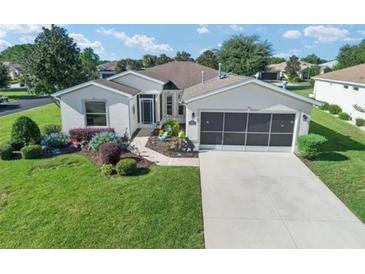 Single-story home with attached garage, landscaped yard, and driveway at 15842 Sw 11Th Terrace Rd, Ocala, FL 34473